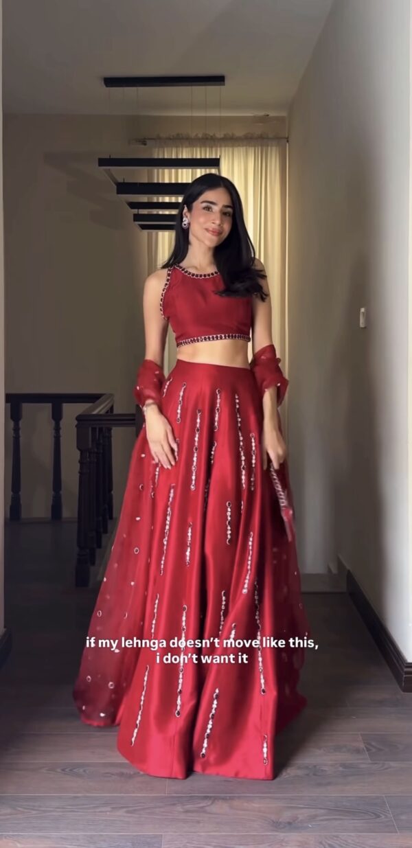 Close up of mirror work lehenga fabric in crimson red